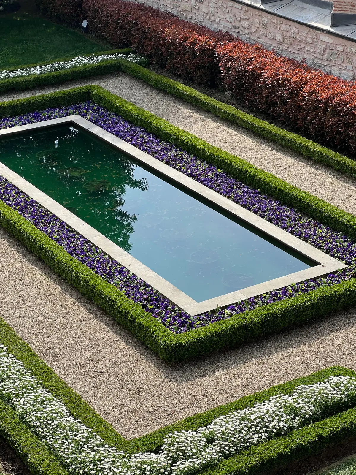 Formal garden with neatly clipped hedges and reflecting pool